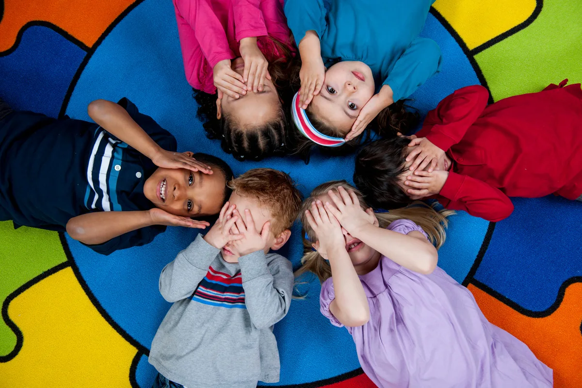 Niños acostados en círculo jugando