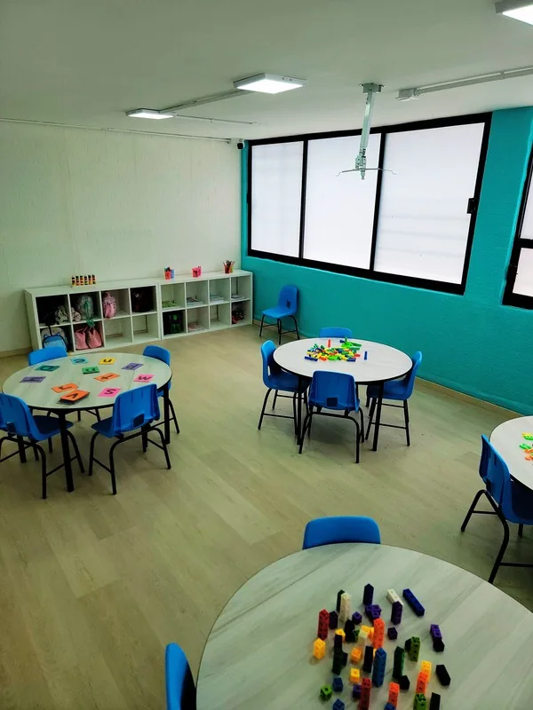 Salón con mesas redondas y sillas azules